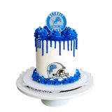 Cake with blue and white decorations featuring a Detroit sports team logo on a white background
