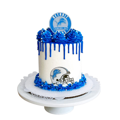 Cake with blue and white decorations featuring a Detroit sports team logo on a white background