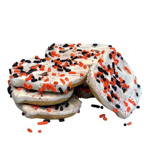 Stack of cookies with white icing and Halloween sprinkles on a white background