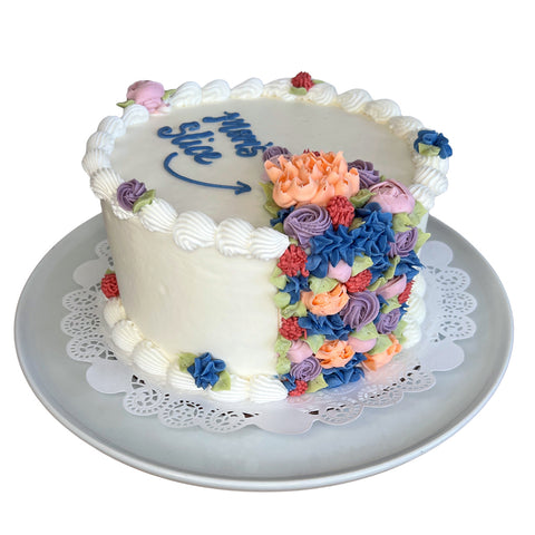 Decorative cake with colorful flowers on a white plate