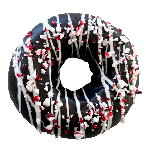 Decorative donut with chocolate glaze, white drizzle, and crushed peppermint on a white background