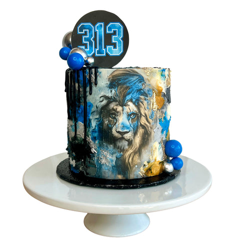 Cake with lion design and number 313 on a white stand