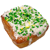 The Home Bakery Kronut with vanilla bean glaze and green and yellow sprinkles on a white background